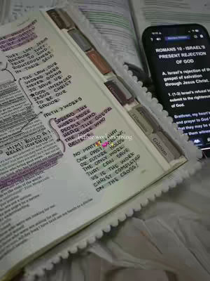 The image shows an open Bible with highlighted text and annotations. A smartphone displaying scripture is placed next to the Bible. The layout is focused with a detailed view of the Bible text.