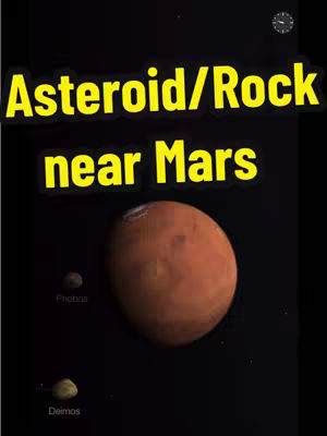 The image shows a dark background with a stylized depiction of Mars and its two moons, Phobos and Deimos. The planet Mars is prominently displayed in the center, colored in shades of orange and red. To the left of Mars, a smaller object is labeled 'Phobos', and beneath that, another object is labeled 'Deimos'. The text overlay 'Asteroid/Rock near Mars' is at the top, using a bold, yellow font outlined in black.