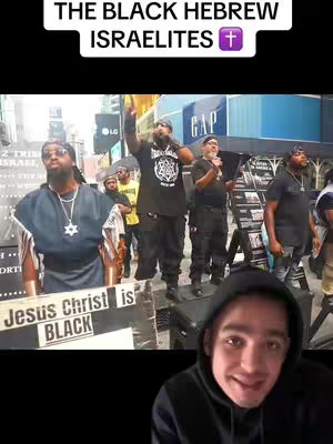 The cover image shows a split-screen view. On the top, it features a scene of several Black people in an outdoor setting holding microphones and signs, addressing an audience. The bottom part of the screen showcases a young man in a hoodie, looking at the viewer and smiling. The top portion has the text overlay “THE BLACK HEBREW ISRAELITES”, overlaying a purple cross emblem.