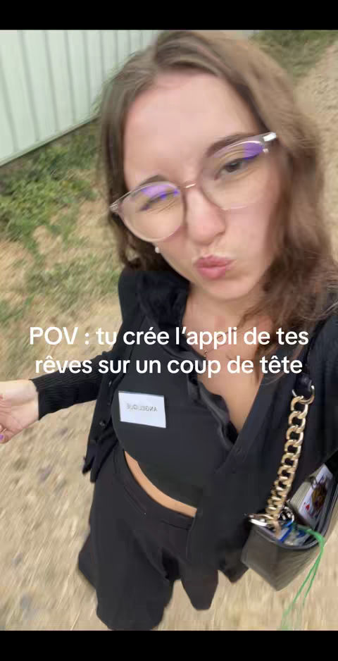 A selfie-style shot of a young woman with glasses, looking towards the camera with a neutral expression. Text overlays are present, and the background suggests an outdoor setting.