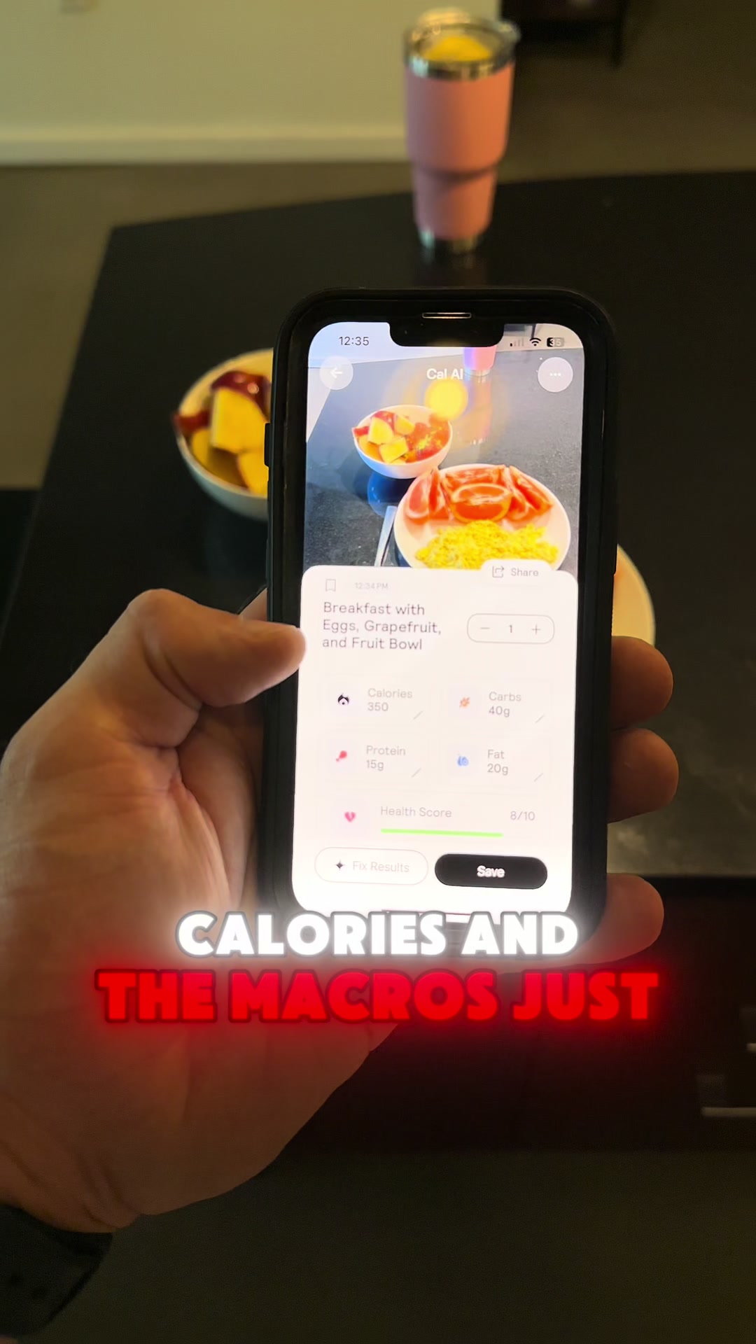 A person's hand holding a smartphone displaying a nutrition app, showing a photo of a breakfast of eggs, grapefruit, and a fruit bowl. Overlayed is red and white text.