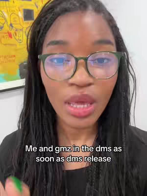 A close-up shot features a Black woman with long, braided hair. She wears glasses and is speaking. A text overlay reads: "Me and gmz in the dms as soon as dms release". The background includes a yellow painting.