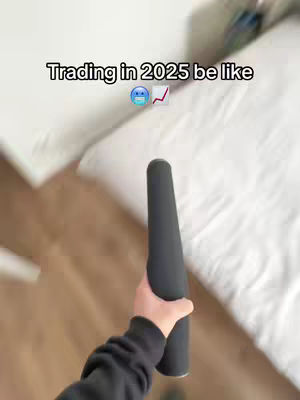 The cover image shows a person's hand holding a black cylindrical object with an elongated shape against a blurred background of a bed and wooden floor. Text overlayed says, 'Trading in 2025 be like' with an emoticon and graph icon.