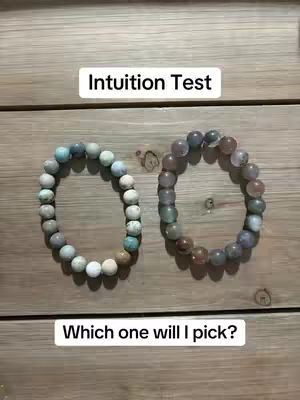 Two bracelets made of round stones are placed on a wooden surface. The bracelets are circular, with one featuring lighter-colored stones and the other darker ones. Text overlays indicate this is an intuition test.