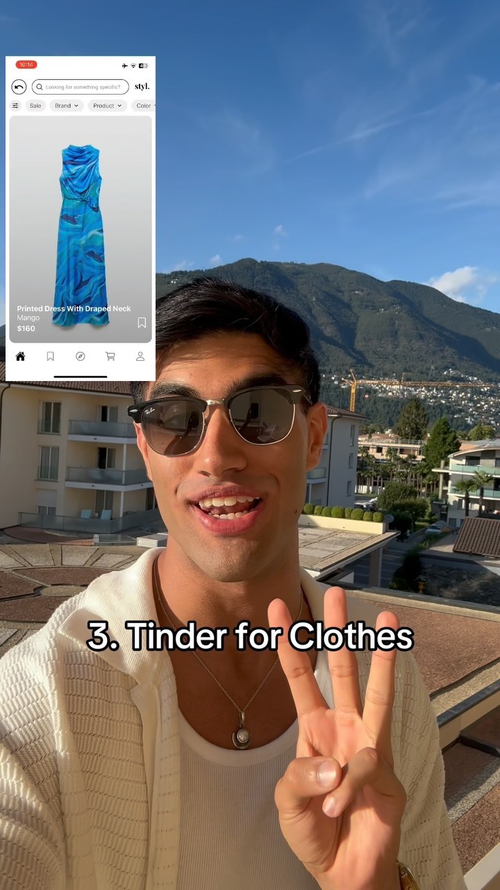 A selfie-style video cover shot featuring a young man smiling. The background shows a serene outdoor setting with a blue sky, mountains, and buildings. The man is wearing sunglasses and holding up three fingers, with text overlaying the image.