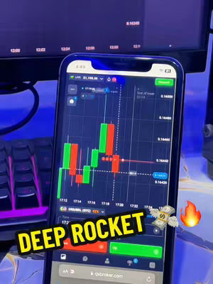 A close-up shot of a smartphone displaying a trading chart, with a keyboard and computer monitor visible in the background. The chart shows candlestick patterns in red and green, with numerical data and time stamps. A cartoon image of cash with wings and a flame are added as visual elements. The words "DEEP ROCKET" are added as hooks in a graphic design.