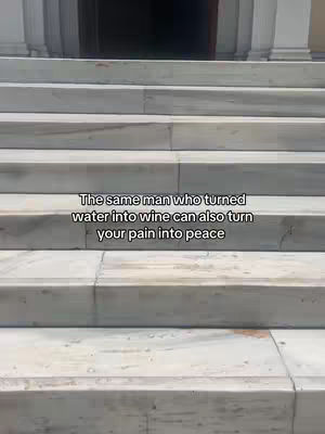 The image shows a set of marble steps leading upwards towards a dark doorway. The steps have a light gray, textured surface, and the whole scene is lit by bright, natural light. Text appears above the steps.