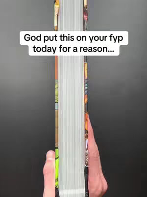 The image shows a vertical view of a book, specifically the spine and pages. The book is held between two hands, with the edge of the pages visible. A text overlay is present near the top. The background is a dark gray.