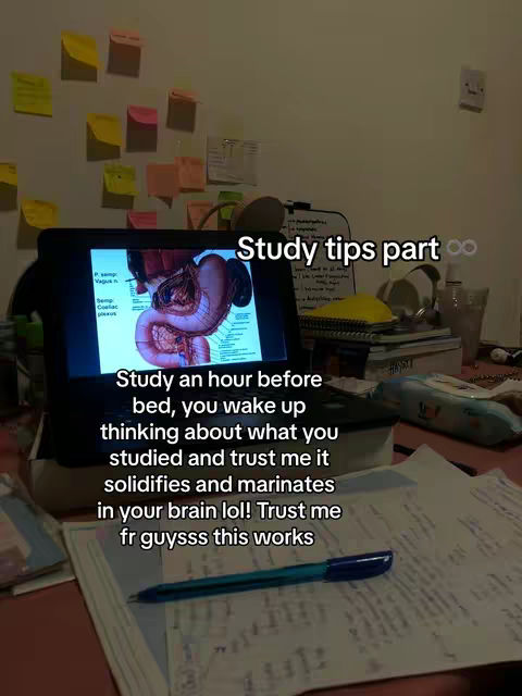 The image shows a cluttered desk with a laptop displaying a diagram of the human digestive system. Text overlays offer study tips. Sticky notes are on the wall, and there is a pen and paper in the foreground.