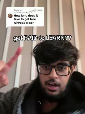 A selfie-style shot featuring a young man with a dark beard and glasses. The background is a blurry, neutral-colored wall. The main subject is pointing with his right index finger upwards, with a speech bubble in the top left corner and text overlayed at the bottom.