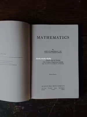 The image shows an open book with the title "MATHEMATICS" on the right page. The book is open on a wooden surface. Across the center of the open pages is the text "study study study".