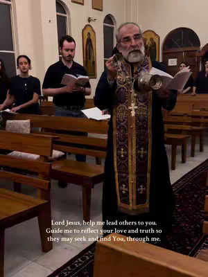 The image shows a church interior with an older man, presumably a priest, holding a censer and a book, appearing to lead a religious service. Two other men and a woman can be seen partially visible in the background. The setting is a traditional church with wooden pews and religious artwork, with a text overlay containing a prayer.