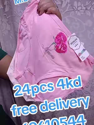The image shows a close-up of a stack of pink women's underwear, possibly a brief or short style, held in a hand. A vibrant pink rose design and the word "Memories" in an elegant script are present on the center of the panty. A small tag with the brand name "HOSAM" hangs to the side. The hook text offers a sale with the price and delivery terms. The background appears to be wrinkled, possibly a bedding or clothing.