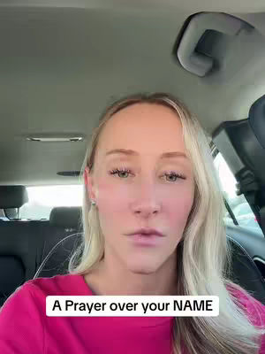 A woman with blonde hair is sitting in the driver's seat of a car. She is wearing a pink shirt and the text overlay reads, 'A Prayer over your NAME.'