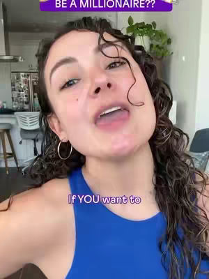 A woman with curly hair smiles and looks up at the camera, with text overlays including a purple banner at the top that says 'BE A MILLIONAIRE??' and another below her that says 'If YOU want to.' She wears hoop earrings and a blue top, and her mouth is open in a speaking position. The background is blurred, suggesting an indoor setting.