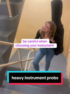 A young woman is on a staircase, carrying a large, black instrument case on her back. She looks up with a slightly concerned expression. Two text overlays are visible, one saying 'be careful when choosing your instrument' and another that says 'heavy instrument probs,' both against colored backgrounds.
