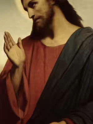 A medium shot of a painting depicts Jesus Christ in profile. He has long, dark hair and a beard, dressed in a red robe with a dark blue draped cloth over his shoulder. A golden halo surrounds his head, and he is gesturing with his right hand.