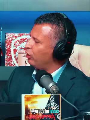 A man wearing a suit and a headset is speaking into a microphone. The background is blurred, but includes what appears to be a flag and a decorative graphic. Text on the cover indicates this could be part of a podcast.