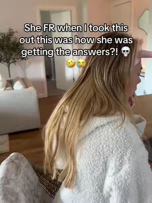 A woman with long blonde hair is seen from the side, wearing a white, fuzzy robe. Text overlays the image, and the background shows a bright, well-lit living room with a glimpse of a doorway. The image has a casual, candid feel, likely taken indoors.