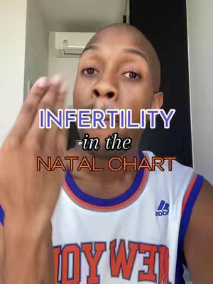 A man with a shaved head is positioned in a well-lit room, wearing a white and blue jersey. Overlayed on the image are the words 'INFERTILITY in the NATAL CHART' in large, stylized text, with an additional element of the man's hand in the frame.