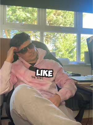 A young man wearing sunglasses and a hoodie is sitting in a chair indoors with a window featuring a view of trees in the background. Overlayed on the image is a white text box.