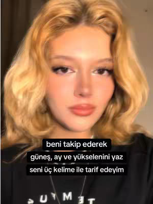 A close-up shot of a woman with blonde hair, looking directly at the camera. Text overlays appear in the bottom center in a black box.