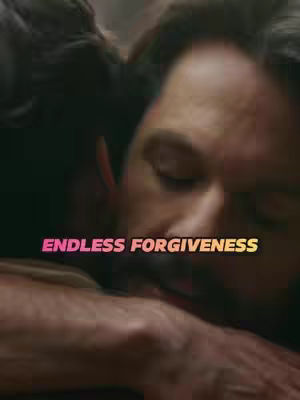 A dimly lit scene captures two men in a close embrace, with one man’s face partially visible, his cheek pressed against the other’s shoulder. The visible man has dark hair. Overlay text in a gradient color spans the center of the image.