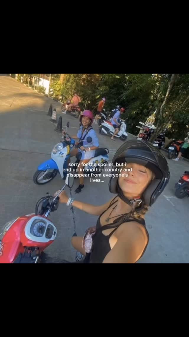 A woman in a black tank top and a black helmet is holding the handle of a red scooter in the foreground, with a group of people riding scooters in the background, one of whom has a pink helmet. Text overlayed on the image says "sorry for the spoiler, but i end up in another country and disappear from everyone's lives..."