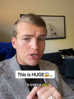 A man with short blonde hair is speaking to the camera. He is wearing a checkered blazer over a black shirt. Text overlays are present with the words, "This is HUGE ..." and "TO CHECK OUT."