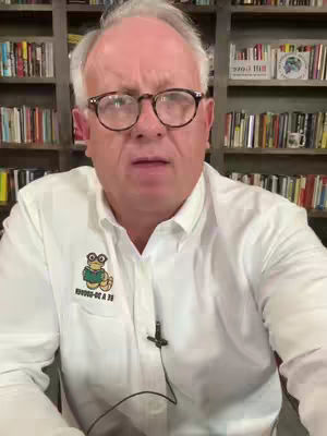 A man with fair skin, glasses, and a white shirt is the focus of this video's cover image. The background features a bookshelf filled with books. The man appears to be looking at the camera with a somewhat serious expression.