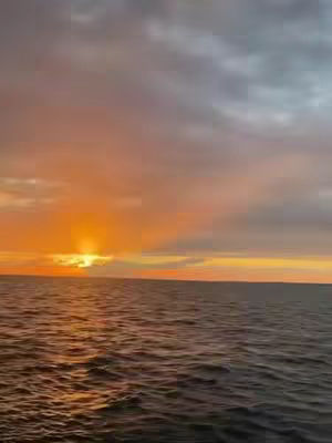 The cover image shows a scenic view of the ocean at sunset. The sky is filled with shades of orange and gray, indicating a cloudy sky reflecting the sunlight. The water is dark, with ripples suggesting gentle waves. The image is well-composed, capturing the natural beauty of the scene.