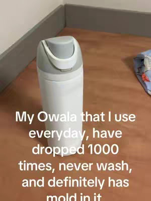 An image of a white and gray Owala water bottle standing on a wooden floor surface, with text overlaid on the image.