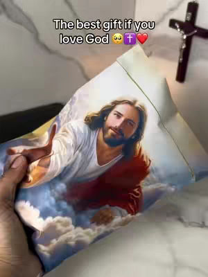 The cover image shows a hand holding a pillowcase with an image of Jesus on it. The pillowcase is white, and the image features a light-skinned, bearded Jesus with long hair, wearing a white robe and a red garment. He is reaching out with his right hand, and the background includes a cloudy sky. A wooden cross is visible in the background, placed against a light-colored wall. The hand holding the pillowcase is also visible, suggesting it is being presented or offered.