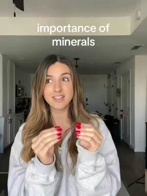 A woman with long blonde hair is the focus, standing in a well-lit room with white cabinets and a glimpse of another room in the background. Above her head, the text "importance of minerals" is visible.