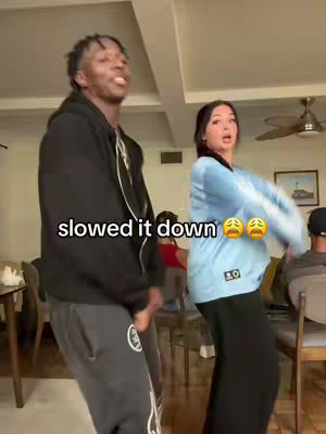 A video cover image shows two young people dancing. On the left, a black man wearing a black hoodie and gray sweatpants is in the foreground. On the right, a woman is in the background, dancing and wearing a light blue shirt and black pants. The text 'slowed it down' is overlaid on the image.