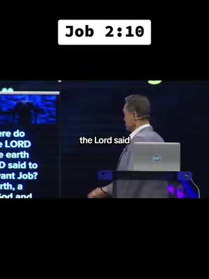 The image shows a man speaking in front of a dark blue background. Text overlayed on the image reads "Job 2:10". The man is wearing a suit and tie. There is also a laptop on screen.