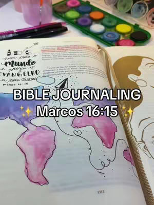An open Bible with watercolor elements, pens and paint supplies scattered around. In the center of the open book, there's a drawing of a world map in watercolor, with "Bible Journaling" and "Marcos 16:15" overlaid as a title in the middle. Text and handwritten notes surround the central image.