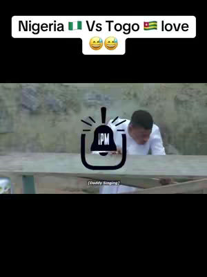 The cover image presents a scene from a humorous video. A man is positioned behind a wooden table. Above, there's text overlay: Nigeria π³π¬ Vs Togo πΉπ¬ love, with laughing-face emojis. In the foreground, there is a stylized IPM logo. The scene is shot outdoors with a blurred, neutral-toned background giving a sense of a natural setting which may involve a skit or comical moment.