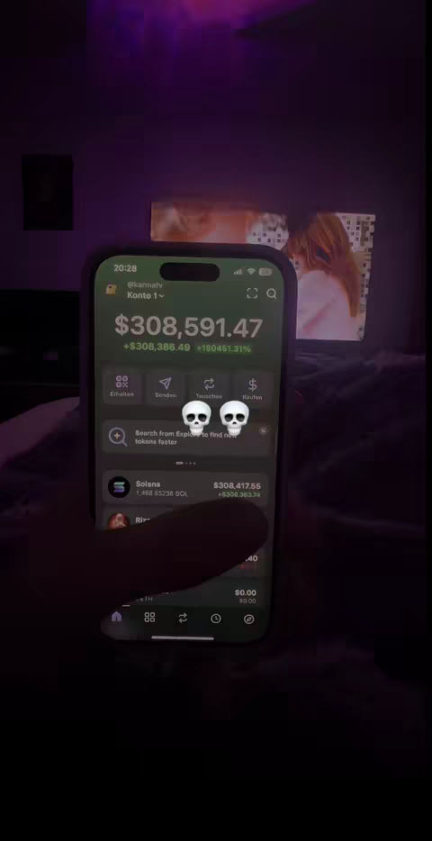 The cover image shows a person holding a smartphone. The phone screen displays a financial app interface, showing a large sum of money represented both numerically and graphically. The background is a dimly lit room, with indistinct objects and a screen showing what appears to be a scene from media.
