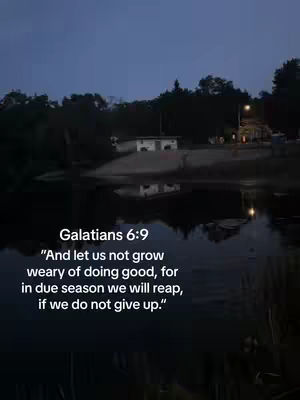 A serene nighttime scene of a body of water with a small building and trees on the far side, and text overlayed with a bible verse.