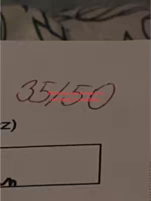 A close-up of a handwritten score on a piece of paper. The score shows a fraction: 35 over 150, written in red ink. Below the numbers, there's an open rectangle, possibly for a solution or further work, and a portion of a similar shape is visible to its side, along with abstract patterns in the background.