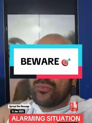 A man is speaking to the camera, which is framed by a phone screen. The background is blurred, but appears to show interior walls. The image has a red, white, and blue color scheme with text overlays: 'BEWARE' with a target symbol. At the bottom of the screen, there are additional overlays, including a date and the phrase 'ALARMING SITUATION', accompanied by an alarm graphic.
