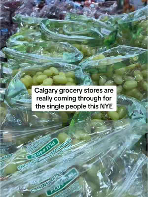 The image showcases a close-up view of numerous plastic bags filled with green grapes, likely in a grocery store. The bags are transparent, allowing the grapes to be visible. The overall lighting appears bright, highlighting the green color of the grapes. The layout emphasizes the abundance of grapes available. A text overlay provides additional context.