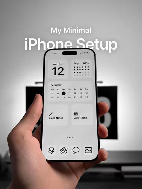 A hand holds a smartphone displaying a minimalist iPhone setup. The screen shows a calendar widget with the date '12' and a 'Day' indicator with dots. Other widgets include 'Quick Notes' and 'Daily Tasks.' The background of the phone is blurred, and the overall image has a clean, modern aesthetic. The color palette is primarily black, white, and gray.