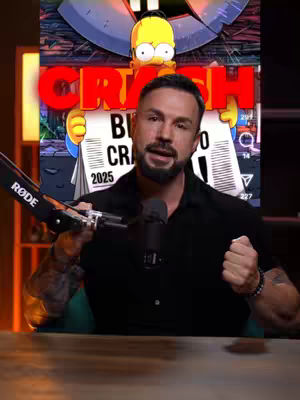 A man with a beard and tattoos, wearing a black shirt, holds a microphone. Behind him is an illustrated image featuring Homer Simpson holding a newspaper with the word 'CRASH' in large red letters above him. The newspaper has 'Bitcoin Crash 2025' written on it. The background includes elements from The Simpsons.