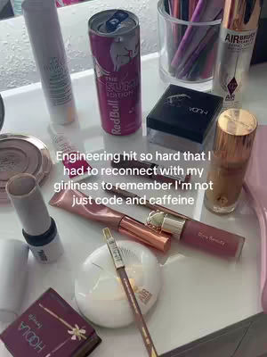 A top-down shot of a white surface covered with makeup products and a Red Bull can. The makeup includes lipsticks, powders, and brushes. White text overlays the image, describing the sentiment behind the image.
