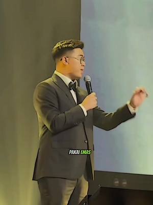 The cover image depicts a man in a suit holding a microphone and gesturing with his right hand in front of a blurred background. The image is well-lit, and a text overlay appears near the bottom of the image.