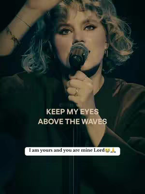 A woman with curly blond hair sings into a microphone. The lighting is dim, creating a spotlight effect. Text overlays read, "KEEP MY EYES ABOVE THE WAVES" and "I am yours and you are mine Lord".