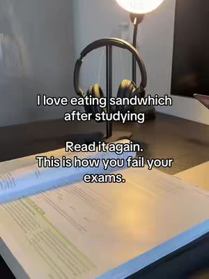 The image shows a desk with a book spread open. Resting on a stand above the book is a pair of headphones. Written over the image are phrases about studying and failing exams.