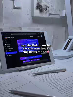 A well-lit interior shot featuring a tablet as the central focus. On the tablet screen, an app interface with a black and purple color scheme is visible, suggesting a learning or study application. The scene includes handwritten notes, a pen, and a desk lamp, contributing to the study or work environment. The overall composition is organized, with items like the lamp and the tablet supporting a calm and functional atmosphere that reflects productivity. In the background, visible wall with paper and some open book are seen.